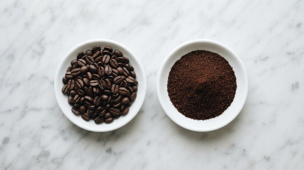 白い大理石の台に、焙煎したコーヒー豆を盛った小皿と、挽いた粉を盛った小皿が並んでいる様子