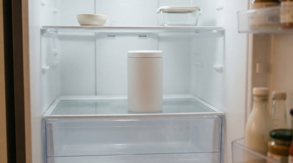 冷蔵庫の棚に、ふたを閉めた白い円筒形の保存容器が1つ置かれている様子